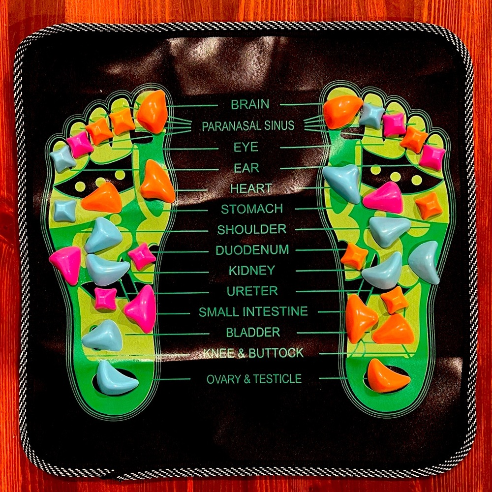 Reflexology foot massage mat with map of acupressure points.